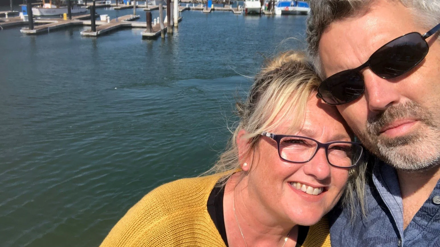 un hombre y una mujer tomándose una selfie junto al agua